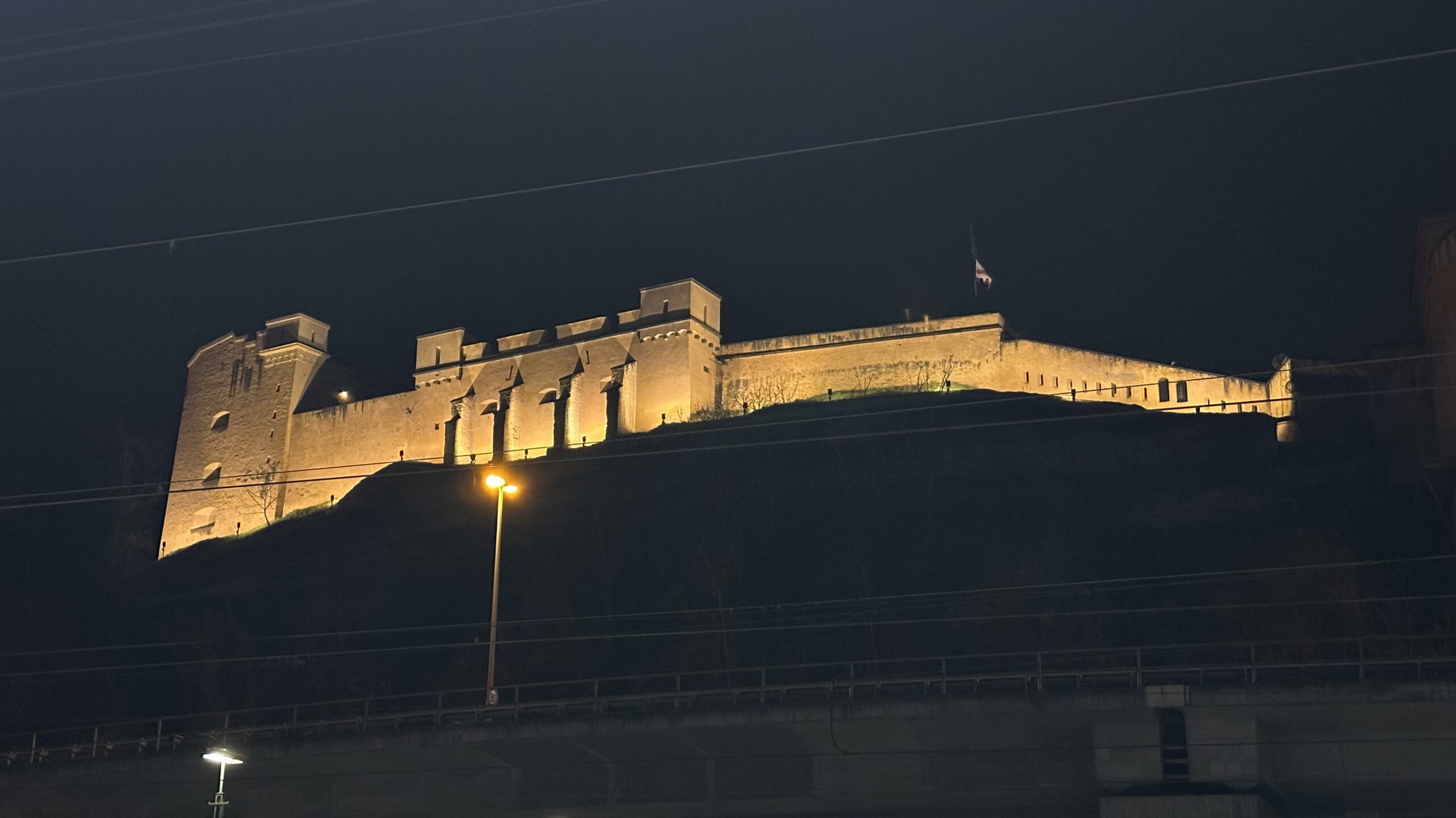 Beleuchtetes Fort Großfürst Konstantin bei Nacht, gesehen vom Hauptbahnhof Koblenz.