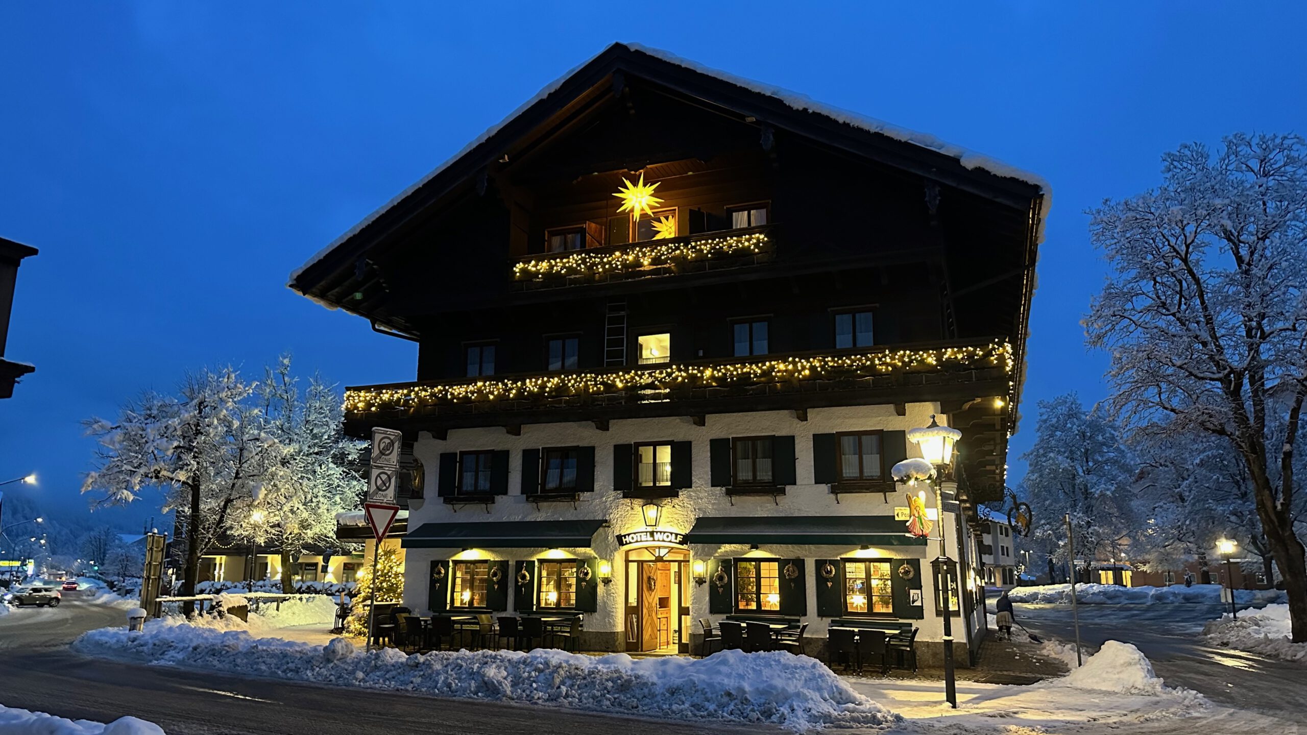 Ein traditionsreiches oberbayerisches Hotel im warmen Lichterglanz einer verschneiten Winternacht.