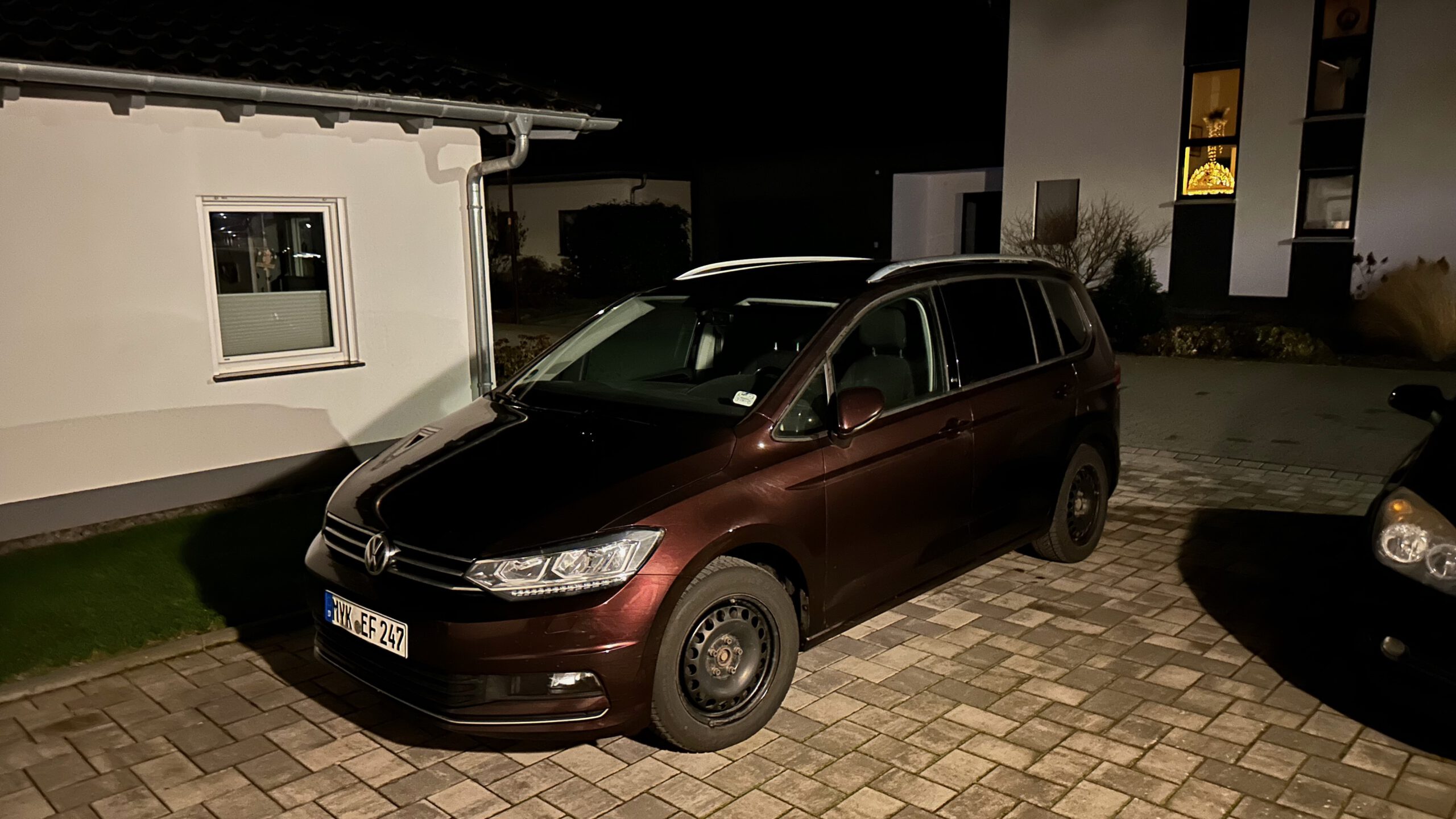 Brauner VW Touran auf einem Hausparkplatz bei Nacht, aufgenommen nach der Rückfahrt aus Oberammergau.